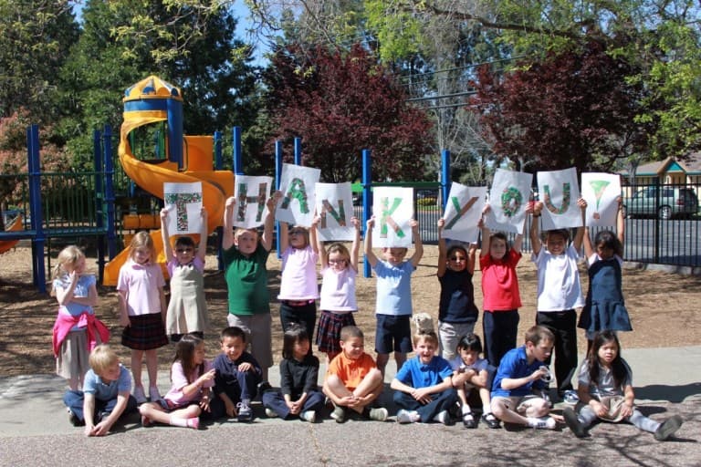 children holding up thank you sign